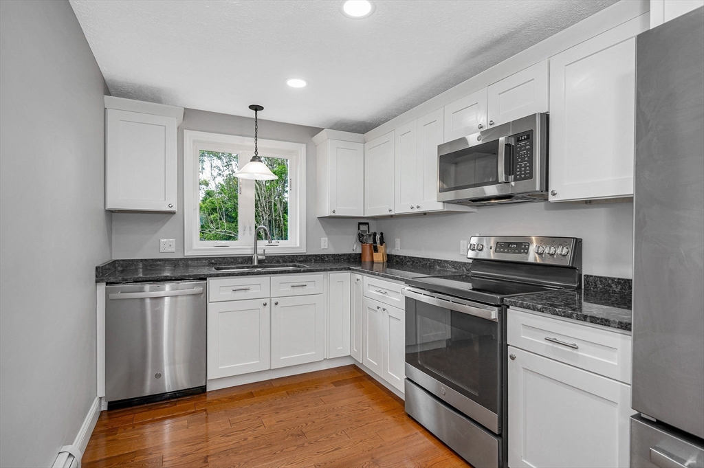 43 West Main Street Orange, MA 01364 - Photo 5 of 32 a kitchen with stainless steel appliances granite countertop a stove a sink and a microwave