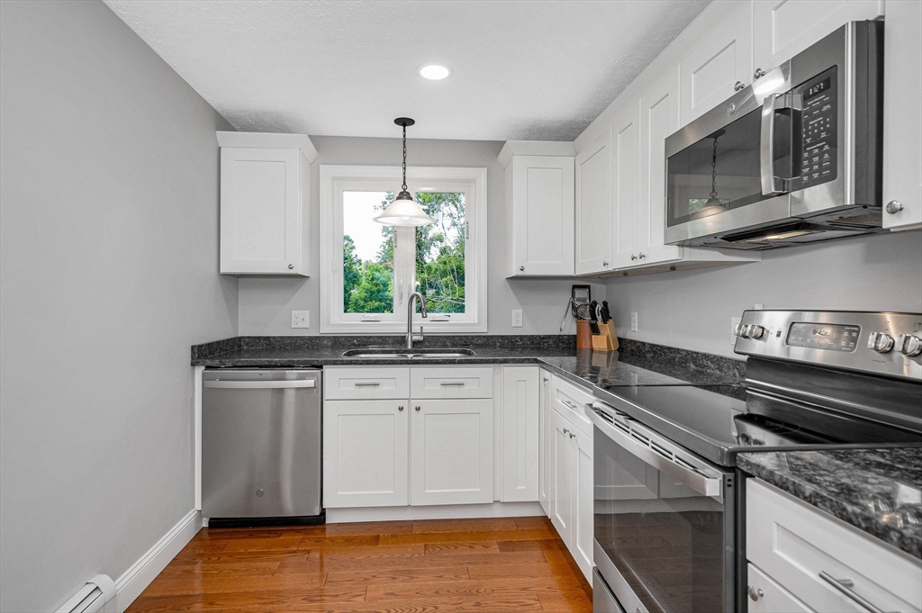 43 West Main Street Orange, MA 01364 - Photo 6 of 32 a kitchen with stainless steel appliances granite countertop a sink stove and microwave