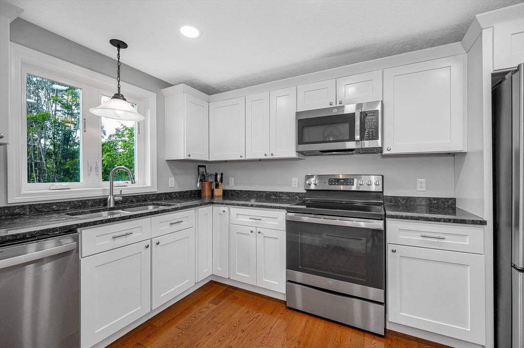 43 West Main Street Orange, MA 01364 - Photo 7 of 32 a kitchen with stainless steel appliances granite countertop a sink a stove a microwave and cabinets