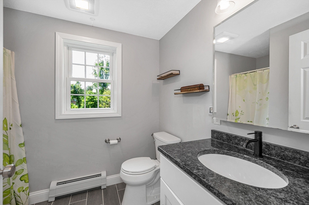 43 West Main Street Orange, MA 01364 - Photo 8 of 32 a bathroom with a granite countertop toilet a sink and a mirror