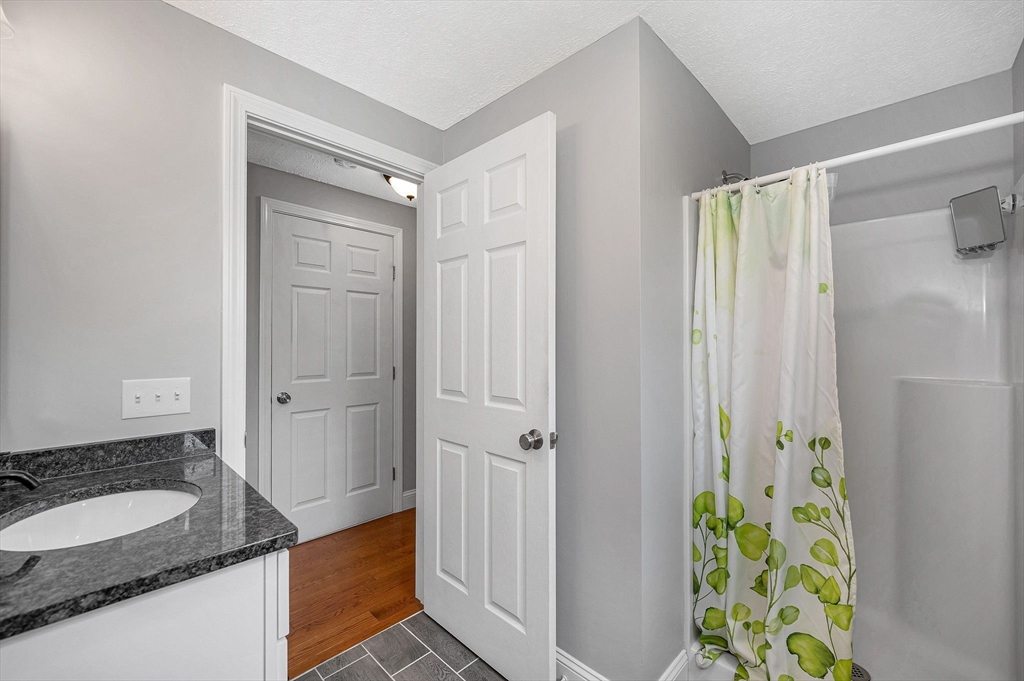 43 West Main Street Orange, MA 01364 - Photo 9 of 32 a bathroom with a granite countertop sink a mirror and a shower