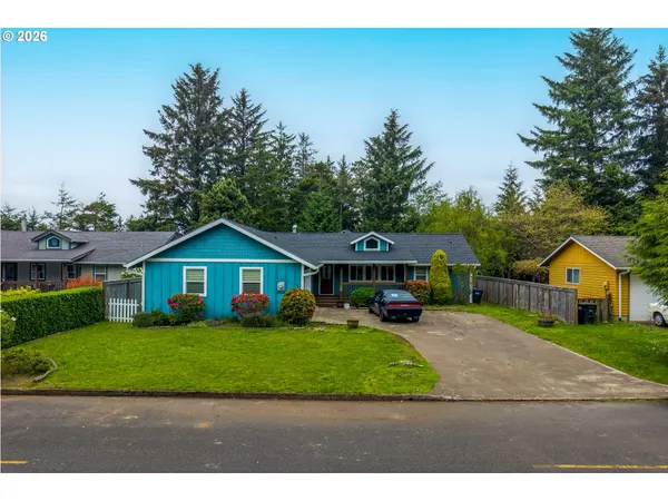 a view of a yard in front of a house with large trees