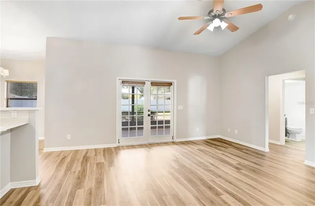 a view of a room with wooden floor and a ceiling fan
