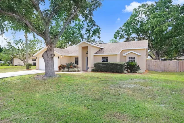 a view of a house with backyard and trees