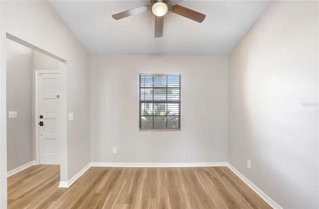 a kitchen with stainless steel appliances granite countertop a refrigerator a stove a sink and white cabinets with wooden floor