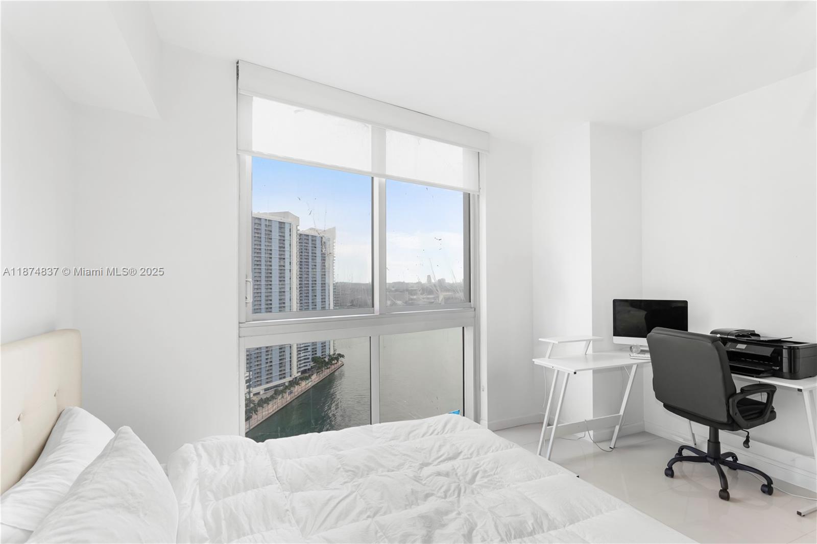 465 Brickell Avenue, Unit 2702 Miami, FL 33131 - Photo 13 of 22 a bedroom with a bed and a chair