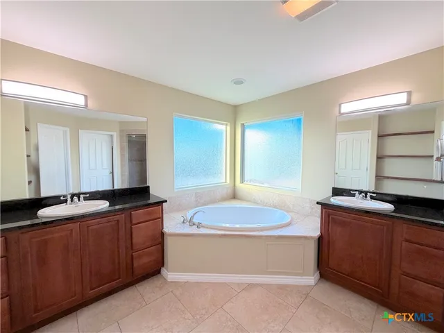 a spacious bathroom with a granite countertop sink and a mirror
