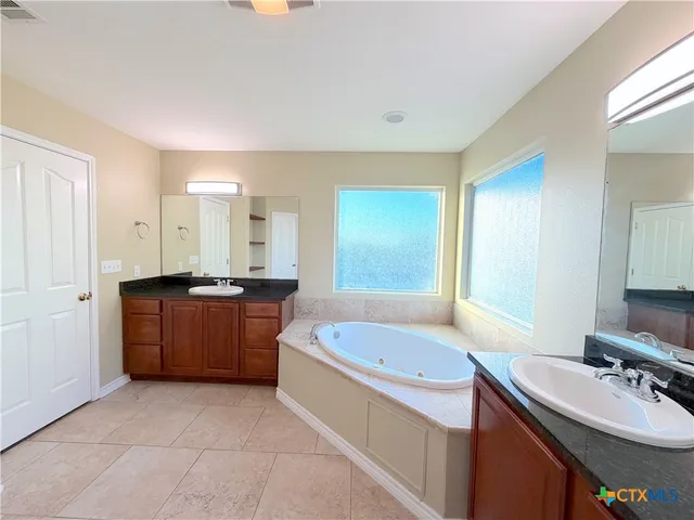 a bathroom with a tub sink and mirror