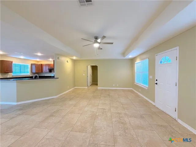 a view of an empty room with a kitchen