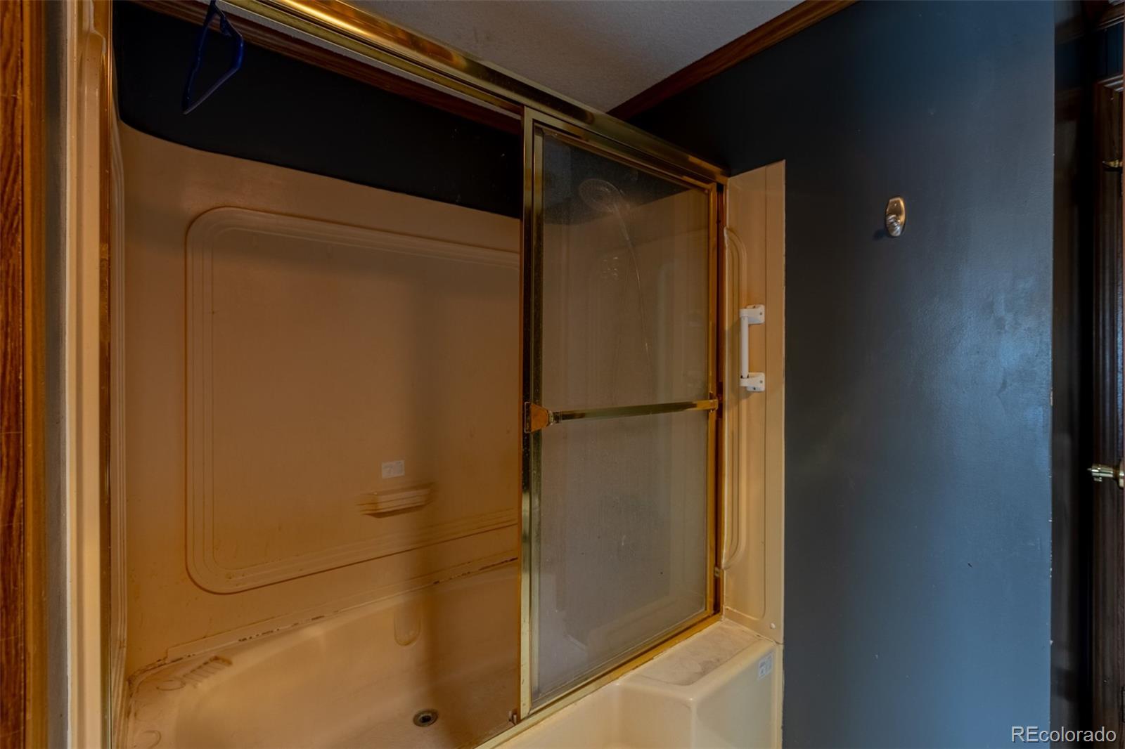 114 6th Street Hugo, CO 80821 - Photo 21 of 50 a bathroom with a glass shower door and sink