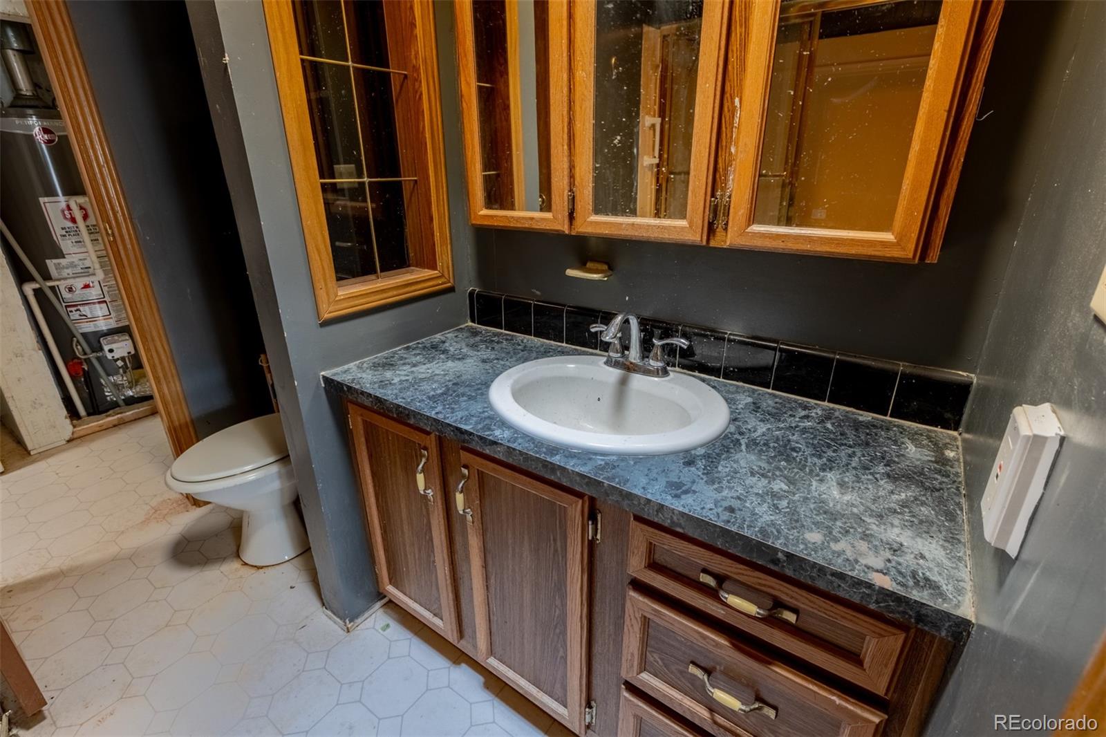 114 6th Street Hugo, CO 80821 - Photo 23 of 50 a bathroom with a sink a toilet and a mirror