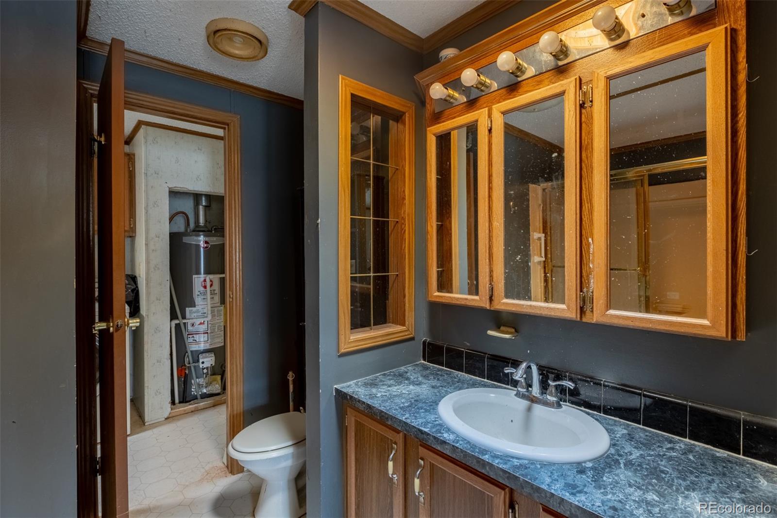 114 6th Street Hugo, CO 80821 - Photo 24 of 50 a bathroom with a granite countertop sink and a mirror