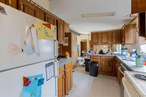 a kitchen with stainless steel appliances granite countertop a refrigerator a stove and a sink