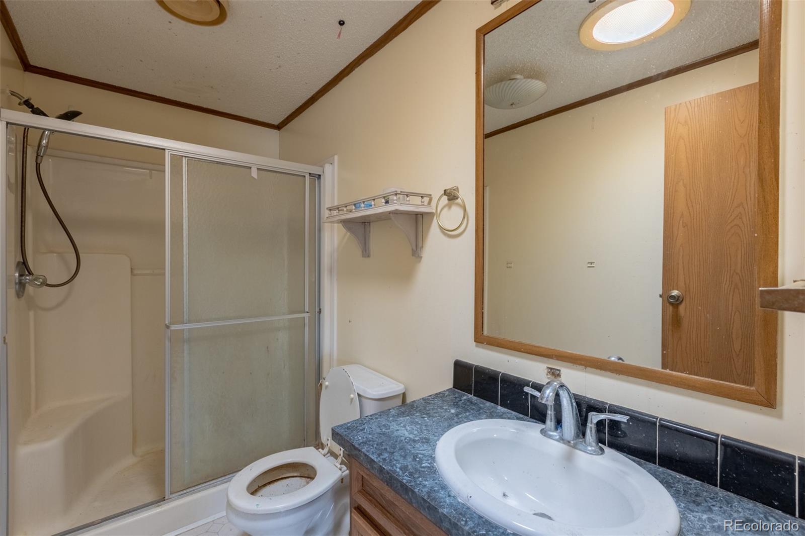114 6th Street Hugo, CO 80821 - Photo 38 of 50 a bathroom with a granite countertop sink toilet and shower