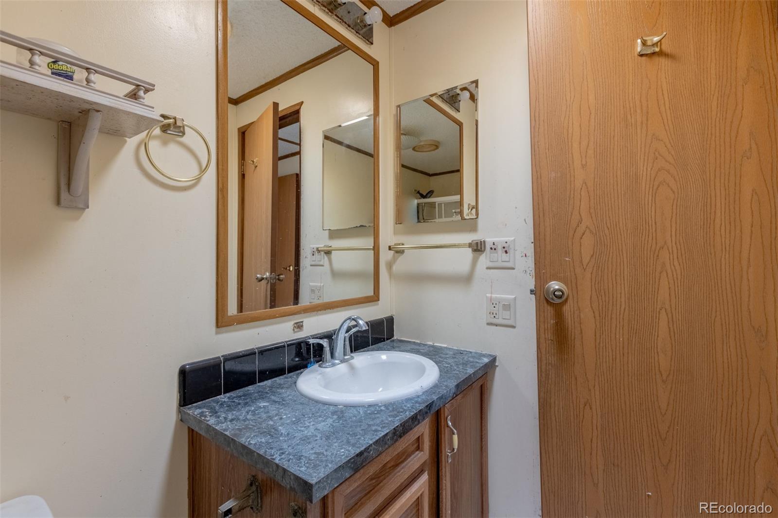 114 6th Street Hugo, CO 80821 - Photo 39 of 50 a bathroom with a granite countertop sink and a mirror