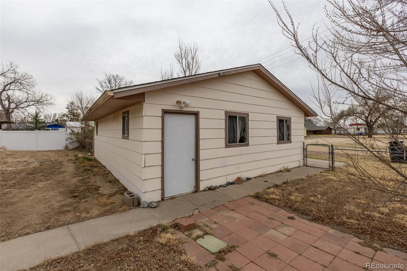 114 6th Street Hugo, CO 80821 - Photo 6 of 50 a view of a white house with a large space in front of it