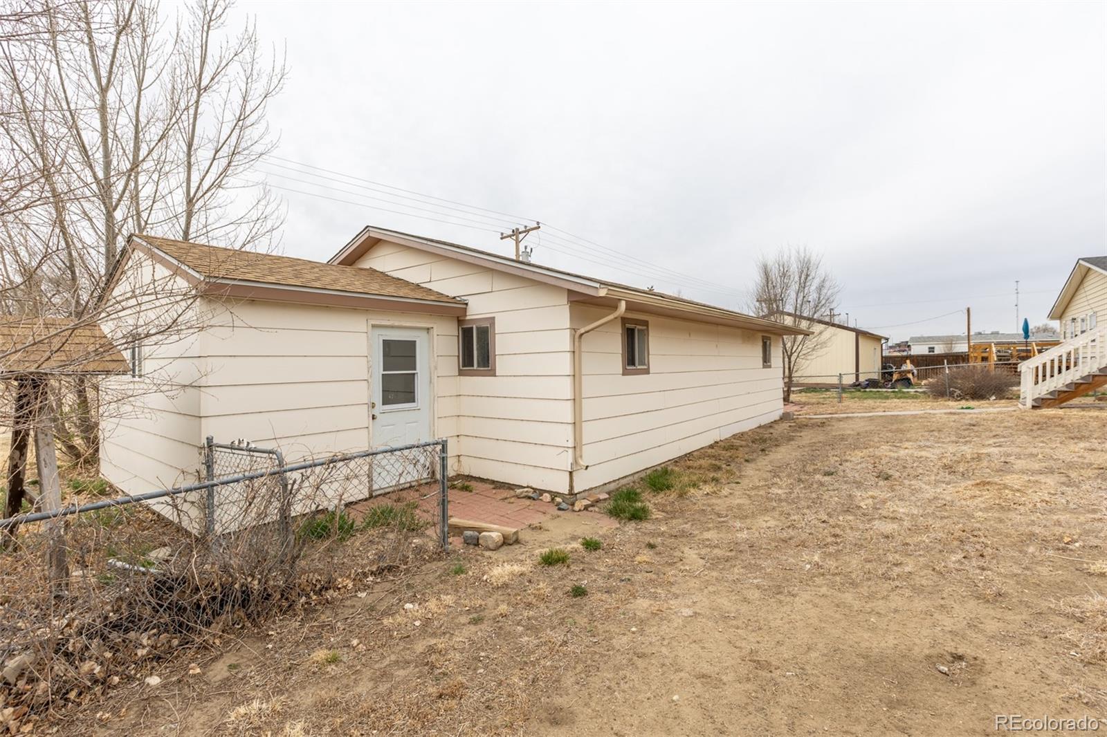 114 6th Street Hugo, CO 80821 - Photo 9 of 50 a view of a white house with a yard and garage