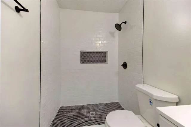 an empty room with wooden floor ceiling fan and windows