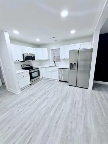 a kitchen with stainless steel appliances wooden floors and wooden cabinets