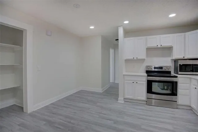 a kitchen with a refrigerator and a stove top oven