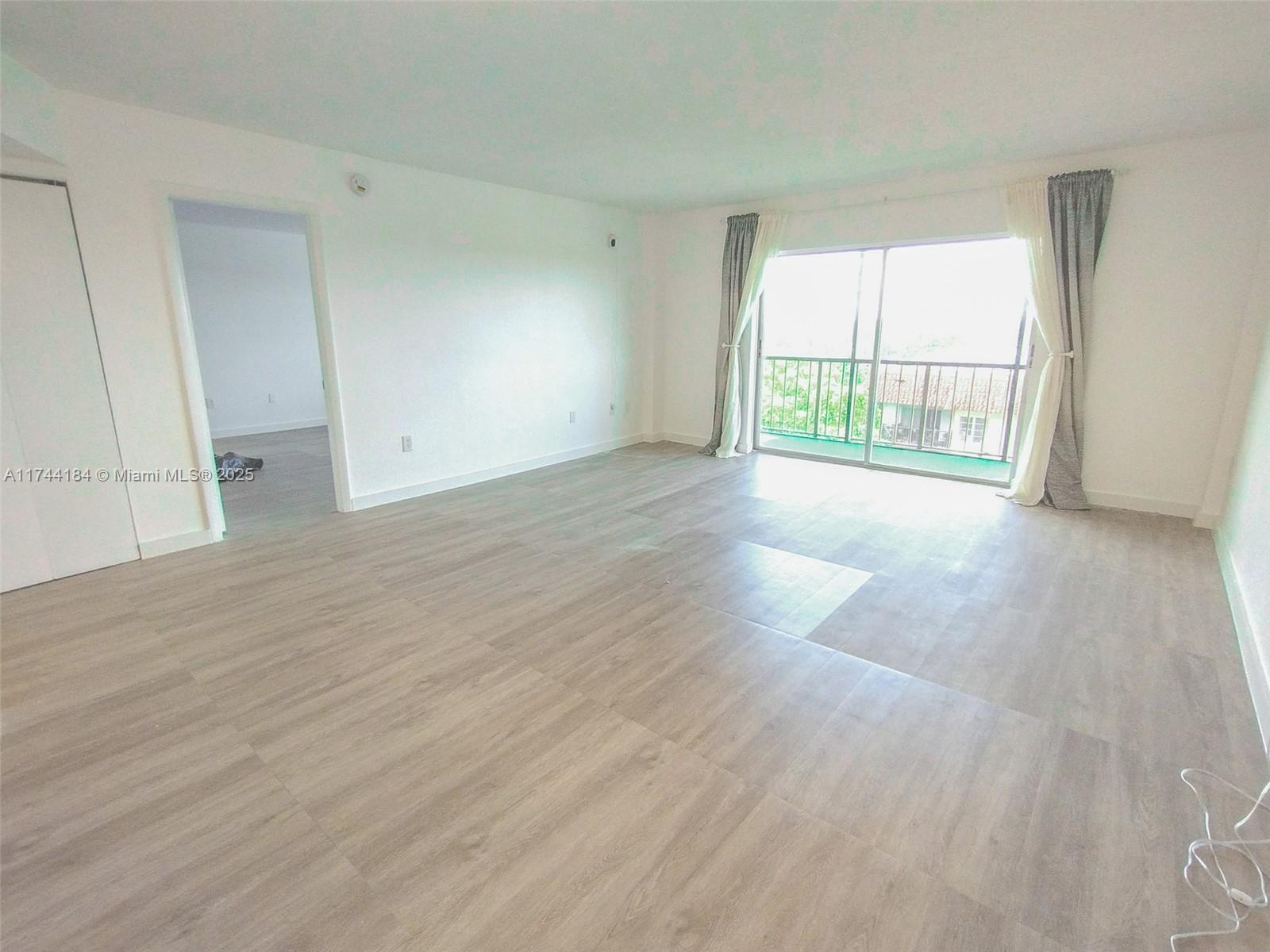 4174 Inverrary Drive, Unit 706 Lauderhill, FL 33319 - Photo 14 of 59 an empty room with wooden floor and windows