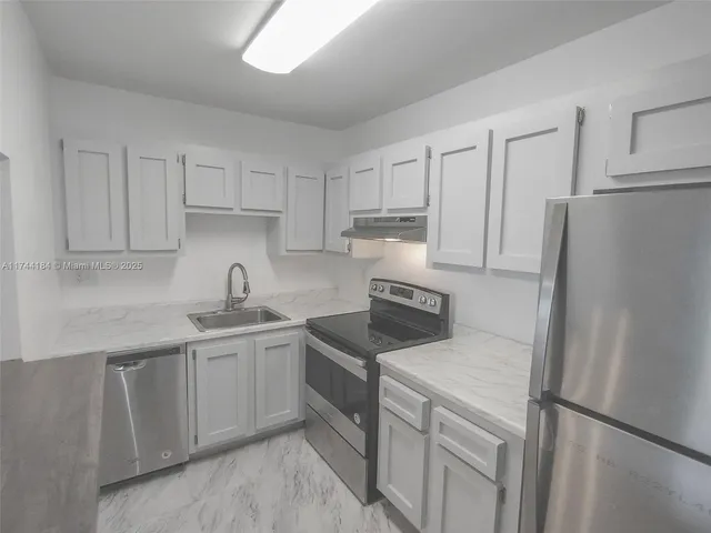 a kitchen with stainless steel appliances granite countertop white refrigerator stove top oven and sink