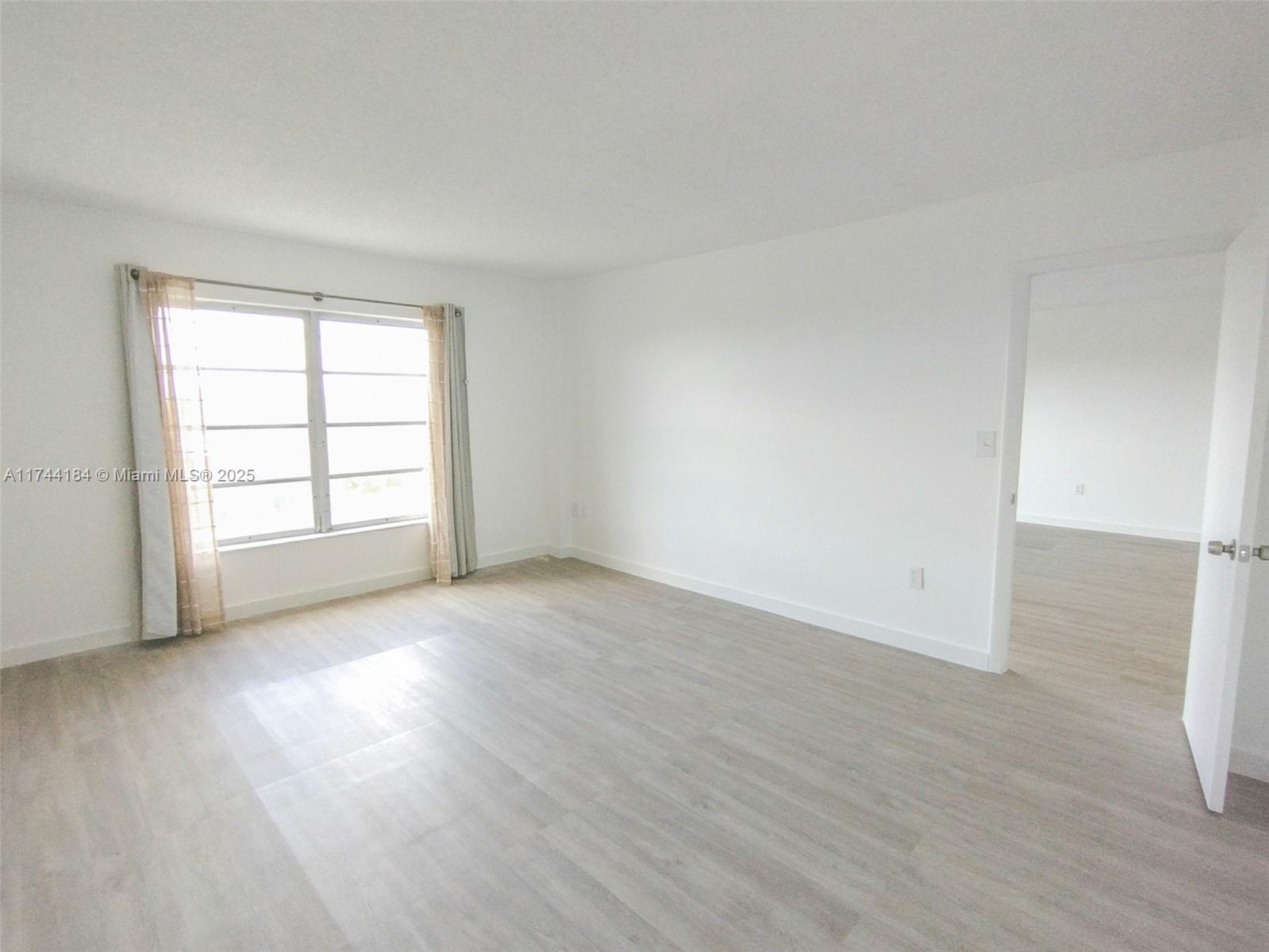 4174 Inverrary Drive, Unit 706 Lauderhill, FL 33319 - Photo 23 of 59 an empty room with wooden floor and windows