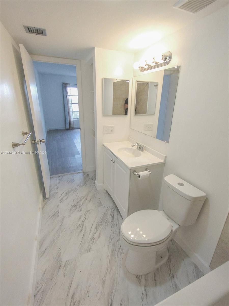 4174 Inverrary Drive, Unit 706 Lauderhill, FL 33319 - Photo 26 of 59 a bathroom with a toilet sink and mirror