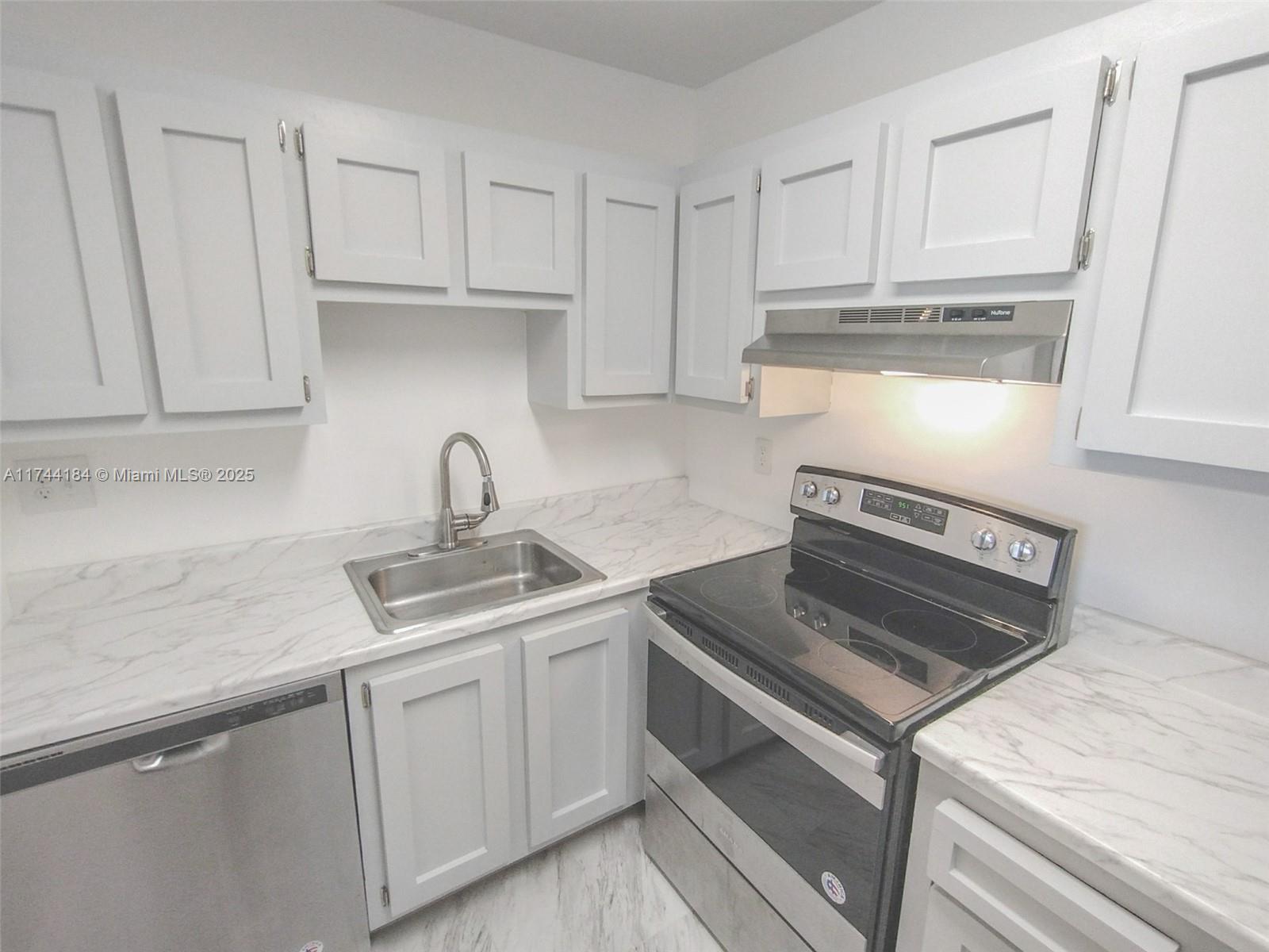 4174 Inverrary Drive, Unit 706 Lauderhill, FL 33319 - Photo 3 of 59 a kitchen with white cabinets and appliances