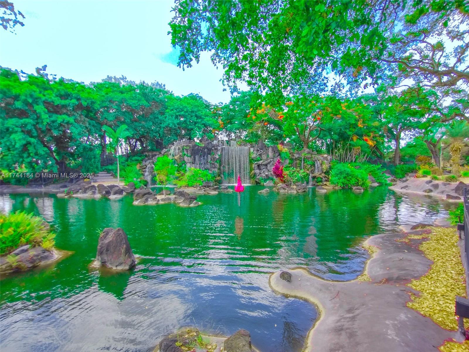 4174 Inverrary Drive, Unit 706 Lauderhill, FL 33319 - Photo 57 of 59 a view of a lake with a garden and a bench