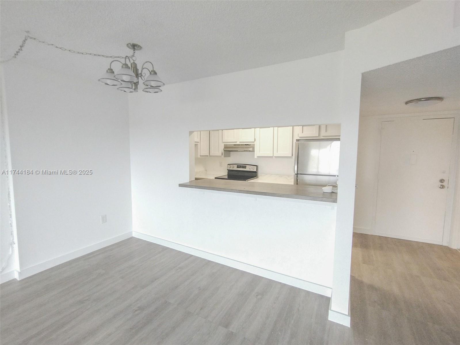 4174 Inverrary Drive, Unit 706 Lauderhill, FL 33319 - Photo 6 of 59 an empty room with wooden floor and window
