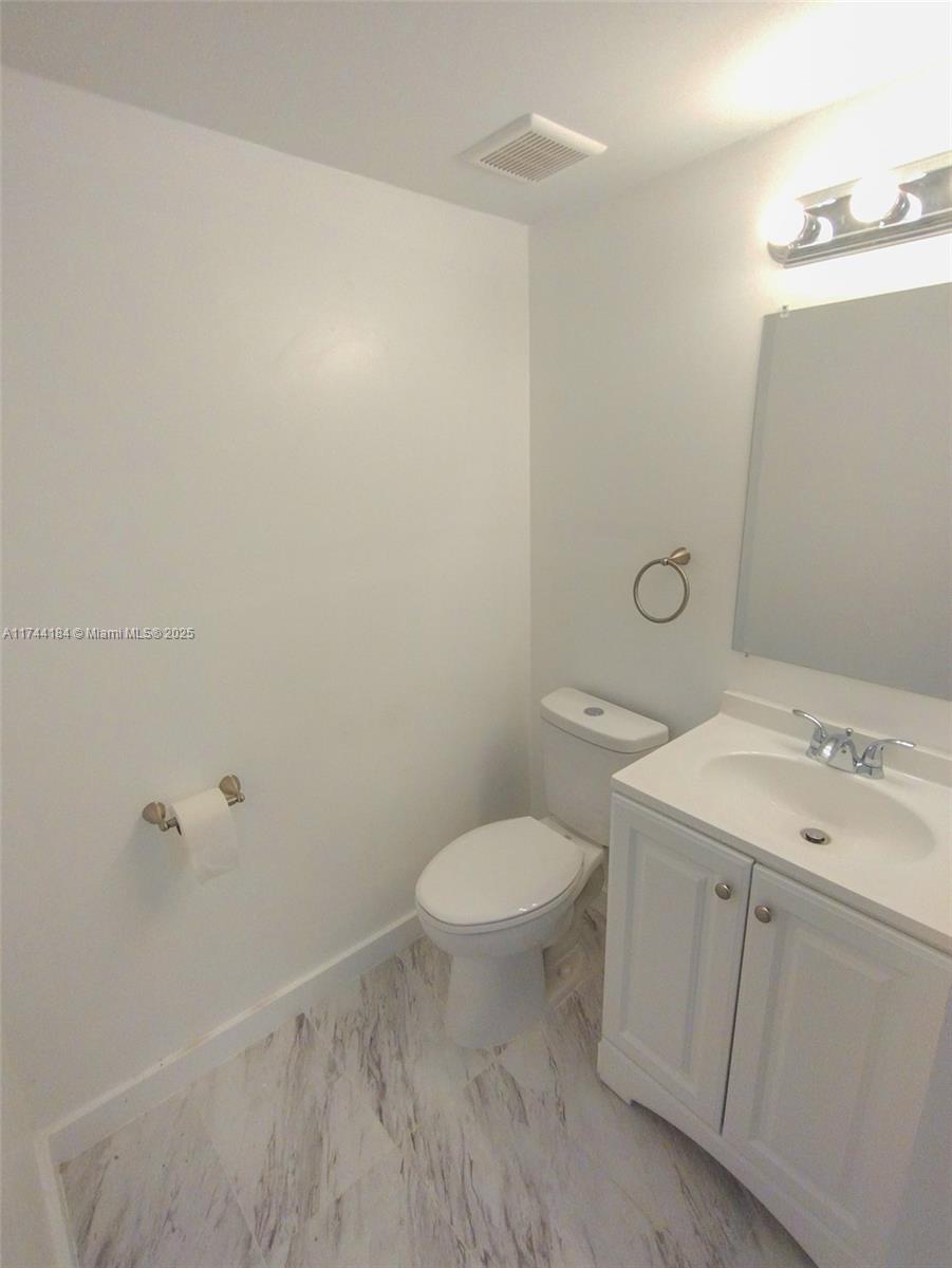 4174 Inverrary Drive, Unit 706 Lauderhill, FL 33319 - Photo 10 of 59 a bathroom with a toilet sink and mirror