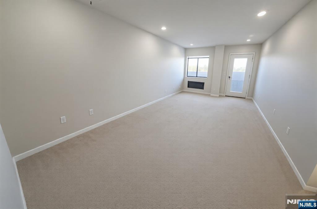 an empty room with windows and entrance to other room