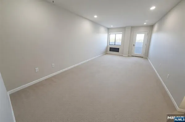 an empty room with windows and entrance to other room