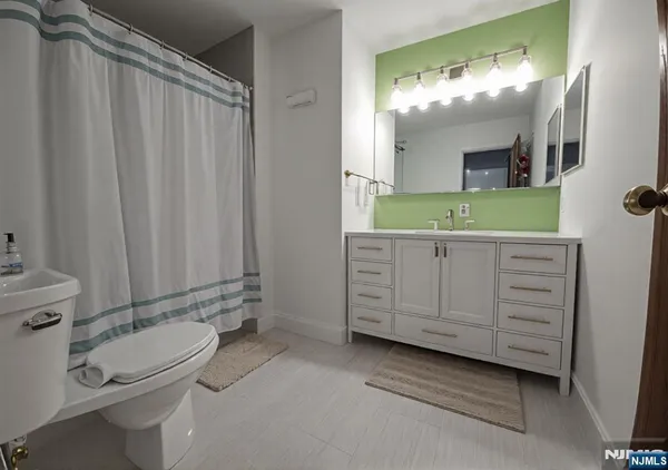 a bathroom with a granite countertop sink toilet and mirror