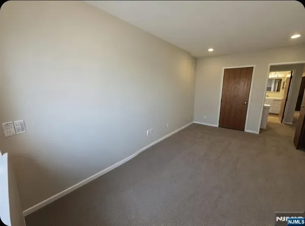 an empty room with closet and mirror