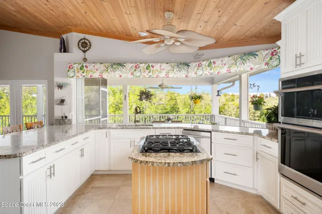 a kitchen with kitchen island granite countertop a sink and a stove