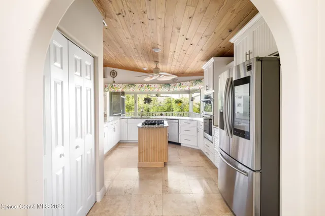 a kitchen with stainless steel appliances granite countertop a refrigerator and a window