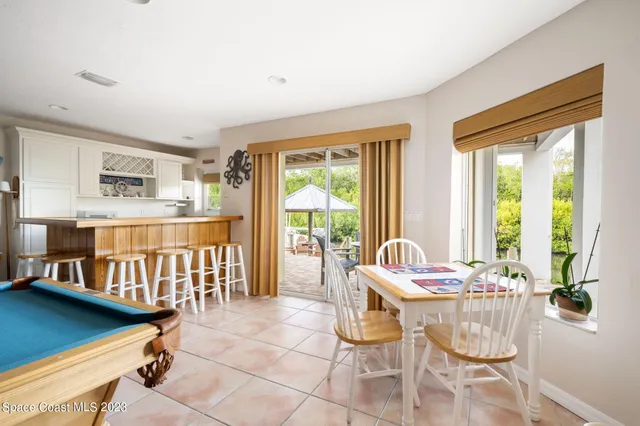 a dining room with furniture and large windows