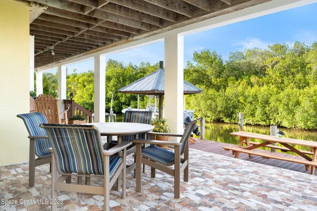 a view of a patio with a table chairs and a swimming pool