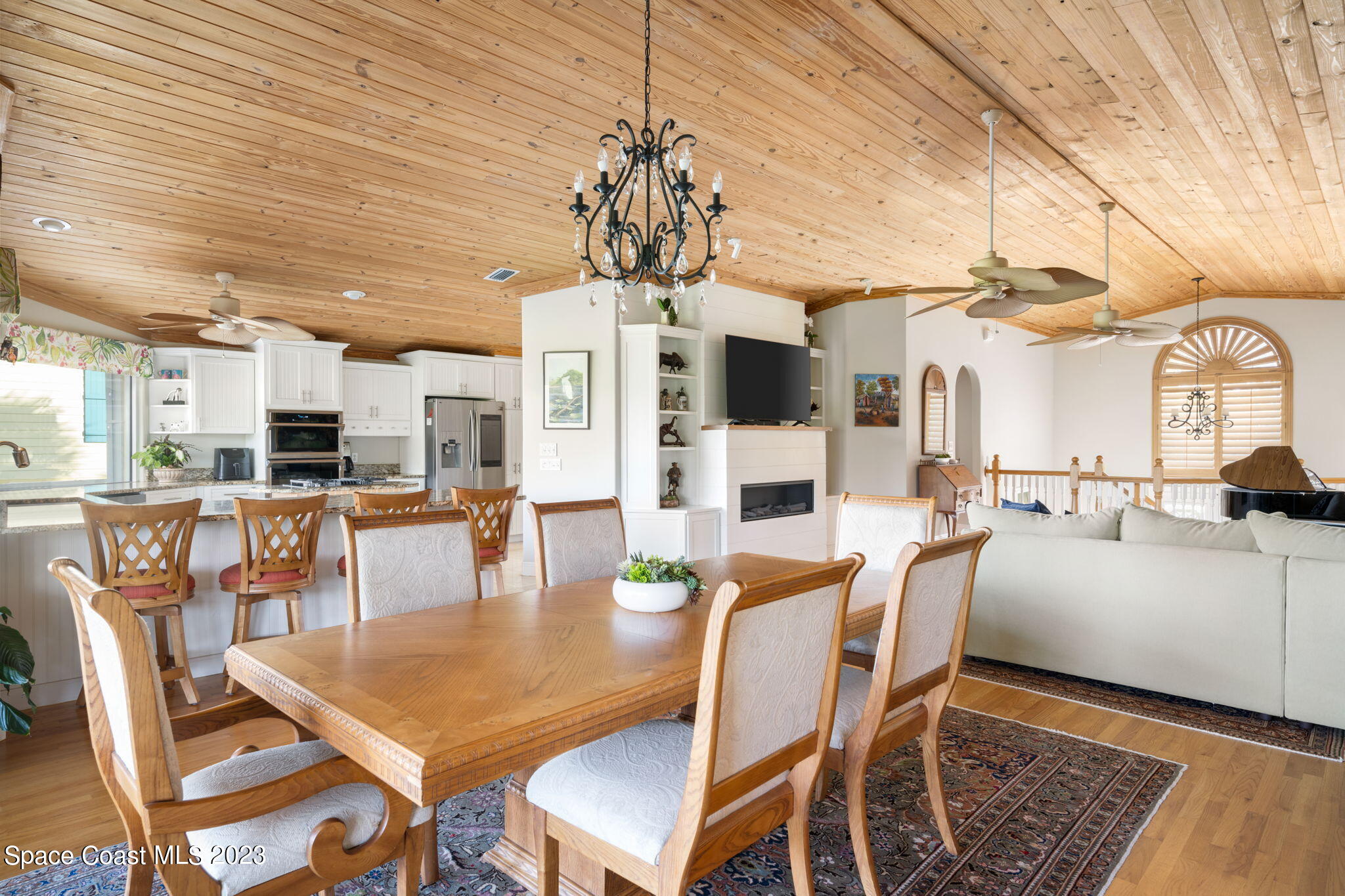 5280 95th Street Sebastian, FL 32958 - Photo 7 of 42 a dining room with wooden floor a chandelier a wooden table and chairs