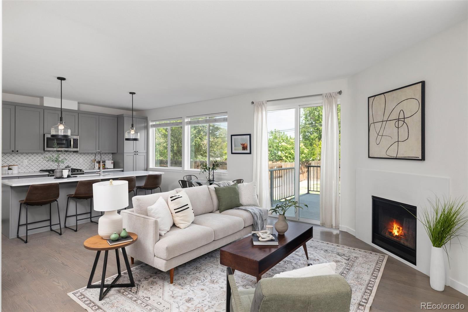 a living room with furniture a large window and a fireplace