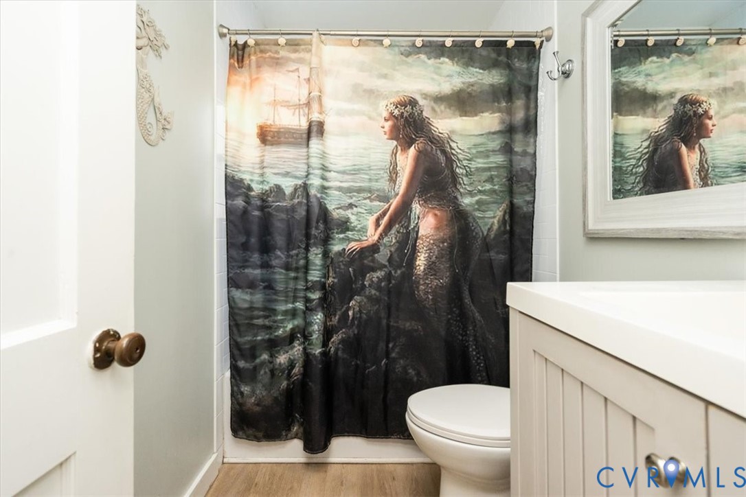 611 Jones Point Beach Road Laneview, VA 22504 - Photo 19 of 27 a bathroom with a toilet a sink and glass door