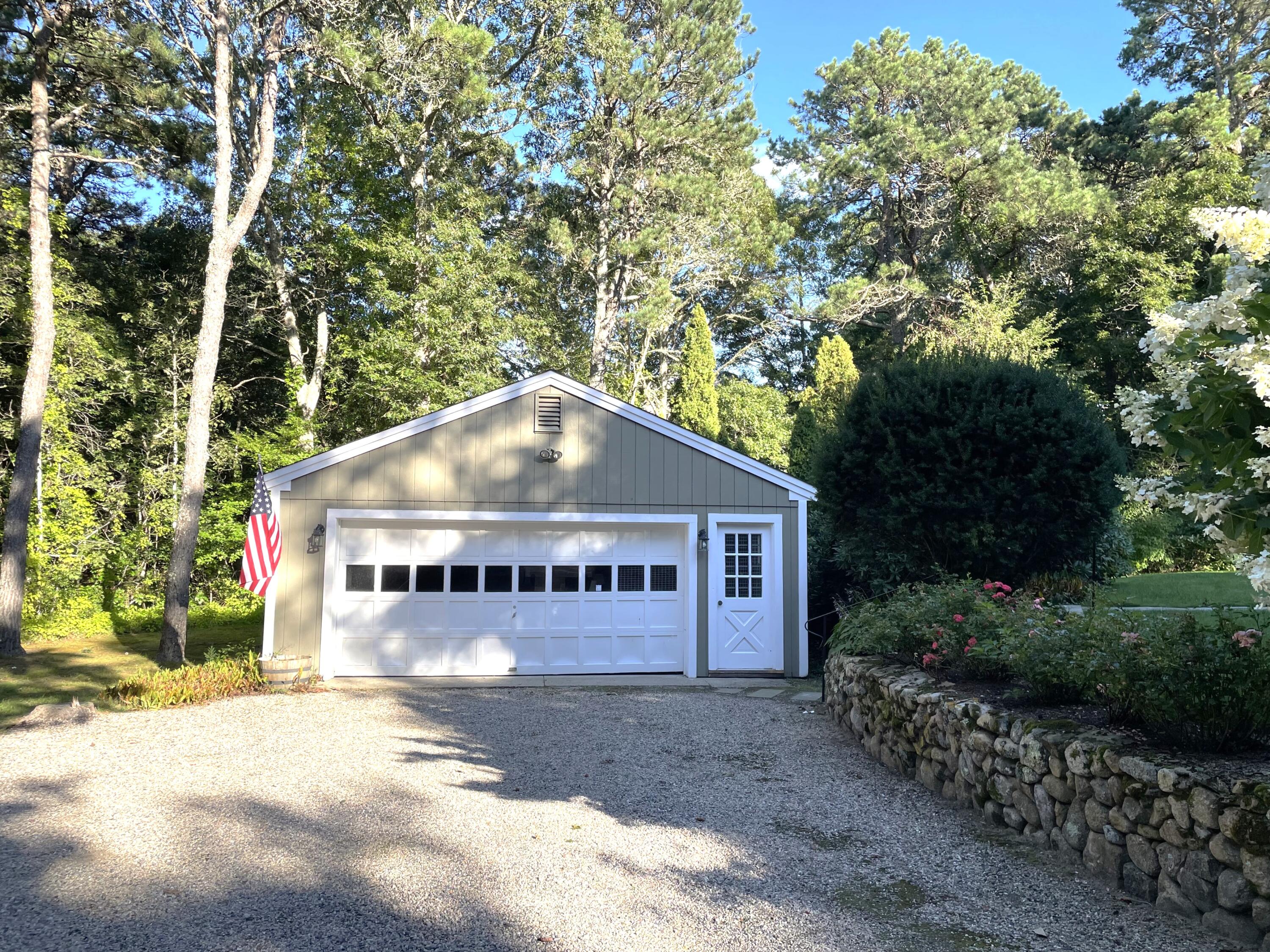 100 Bay Lane Centerville, MA 02632 - Photo 27 of 32 a sign that is sitting in front of a house with large trees