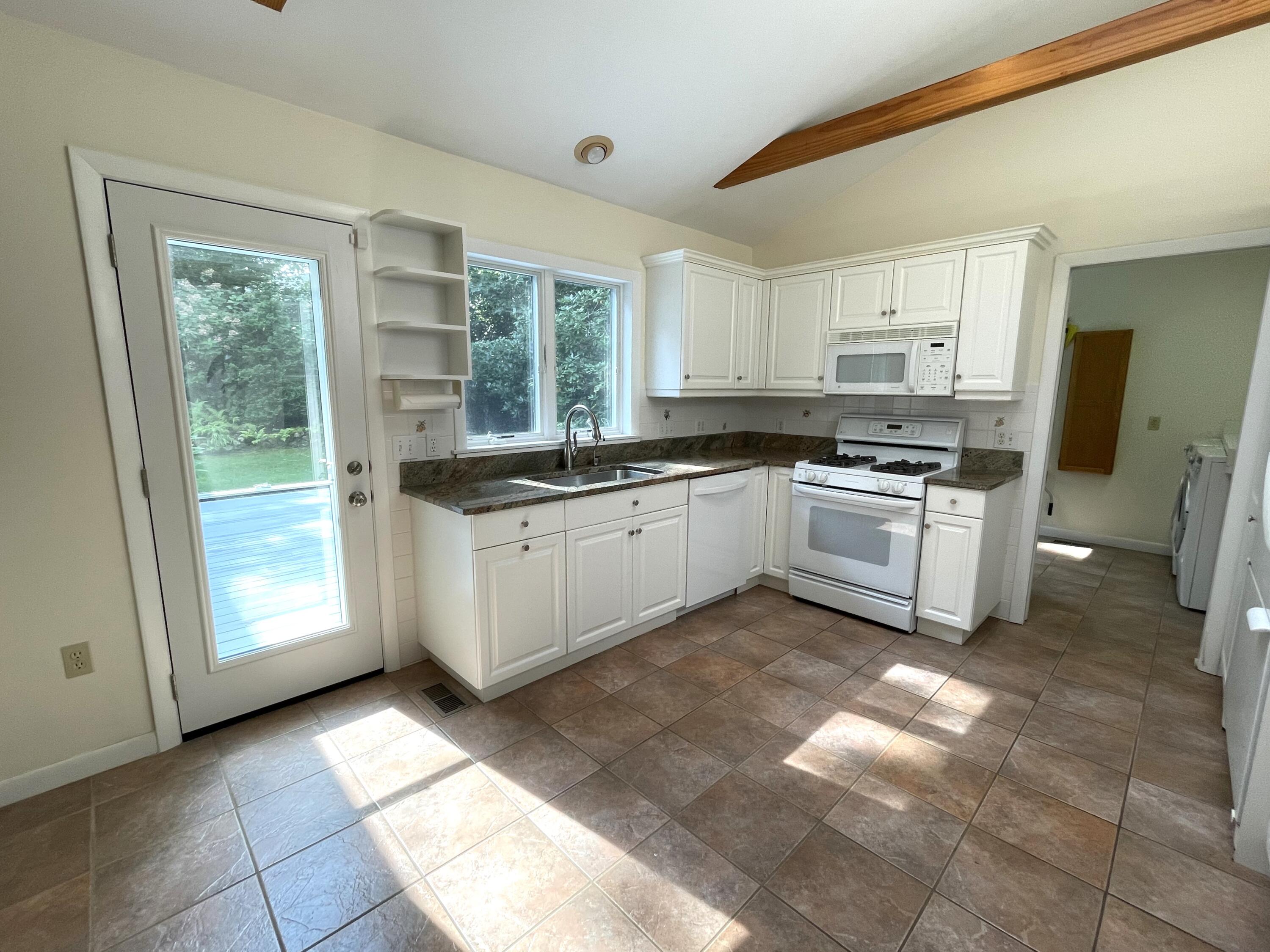 100 Bay Lane Centerville, MA 02632 - Photo 8 of 32 a kitchen with a sink window and cabinets