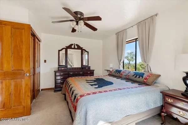 a bedroom with a bed a dresser and window