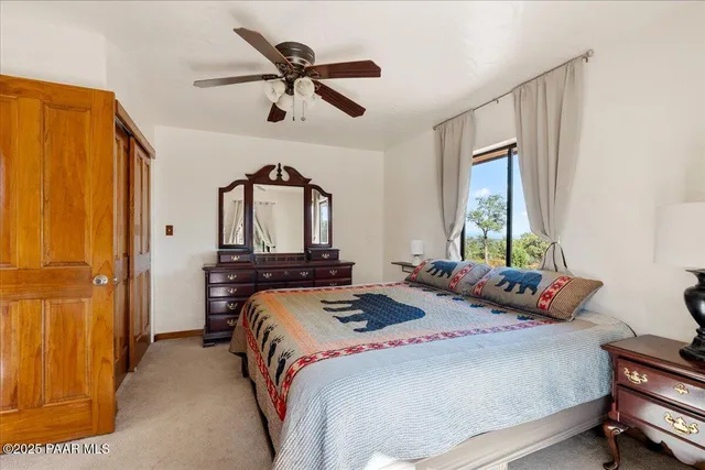 a bedroom with a bed a dresser and window