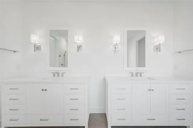 a bathroom with a double vanity sink mirror and
