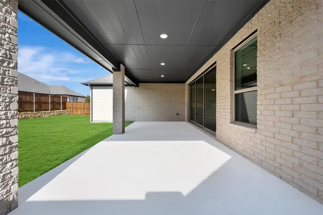 a view of a white house with a big yard and potted plants