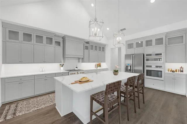 a kitchen with a dining table cabinets appliances and wooden floor